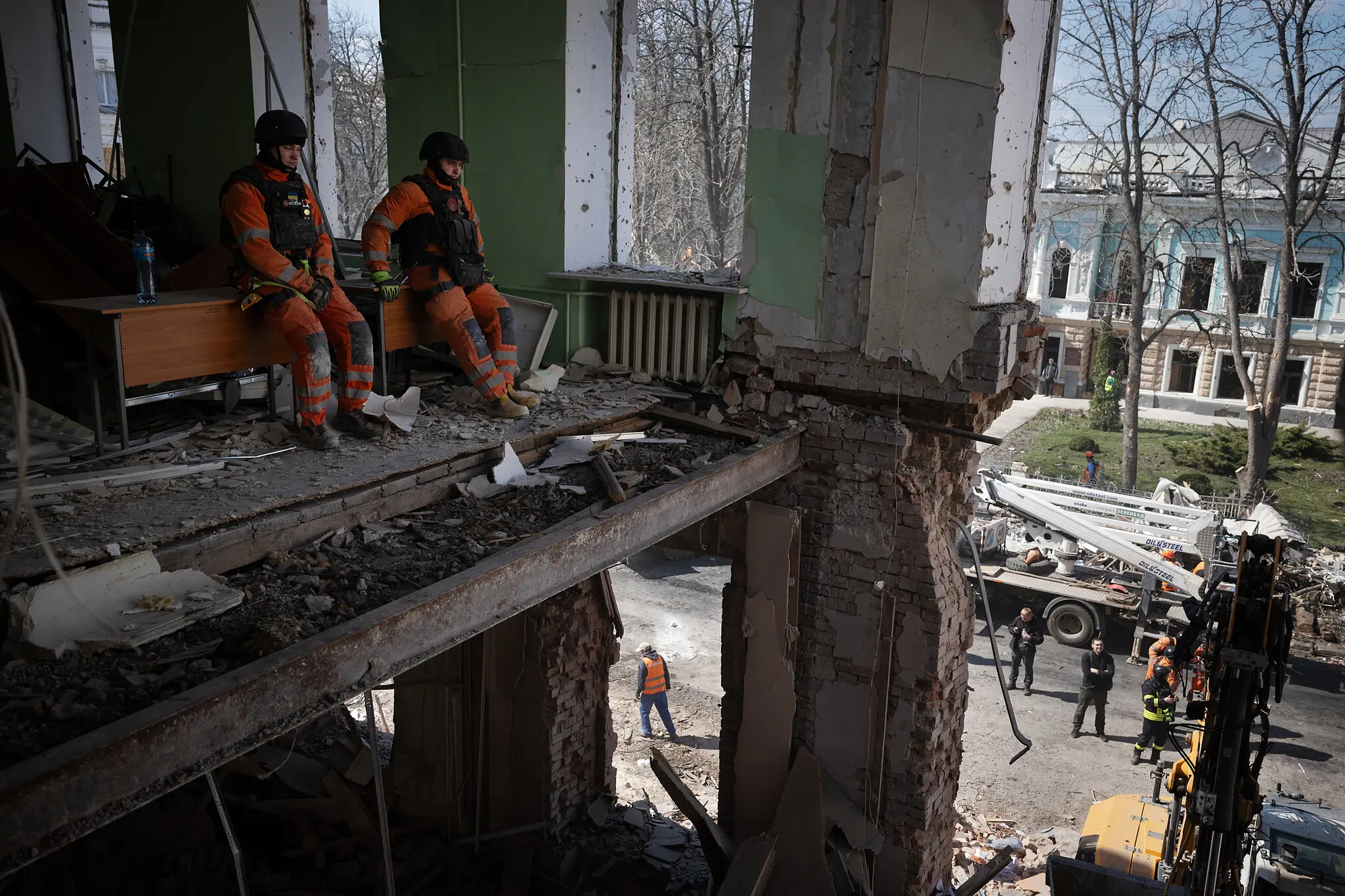 Рятувальники на місці удару двох балістичних ракет у Вербну неділю в центрі Сум, Україна, у понеділок.